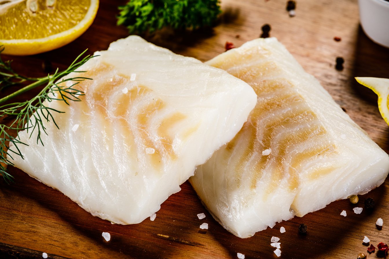 Fresh raw cod fillet on cutting board