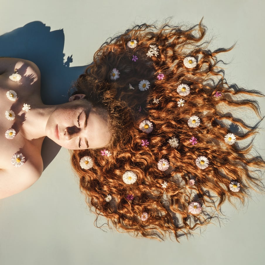 Portrait of young girl with flowers hair.