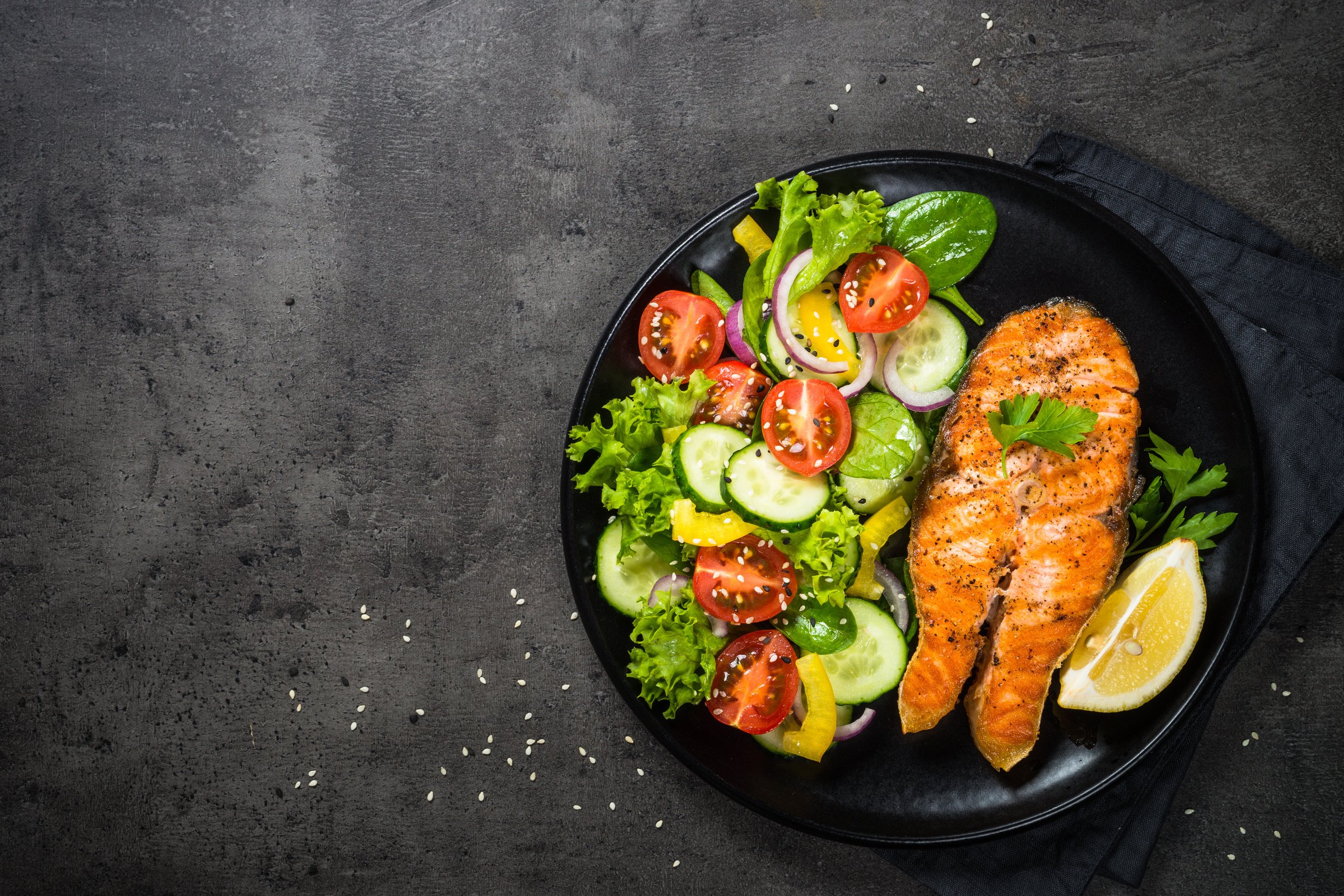 Plate of Salmon and Salad on Concrete Background